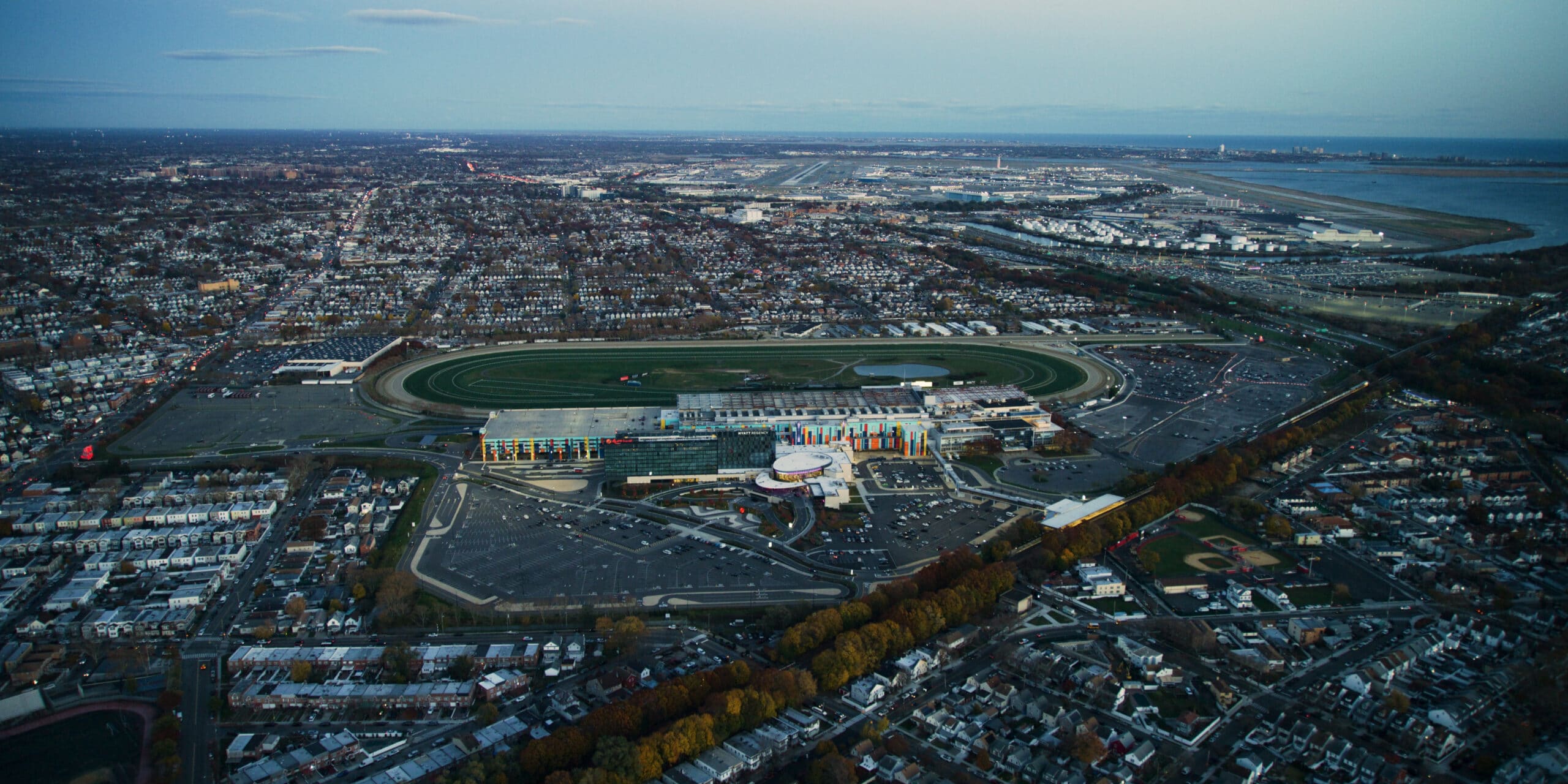 Aerial view of large metropolitan area with sports stadium, airport, and dense residential and commercial development.