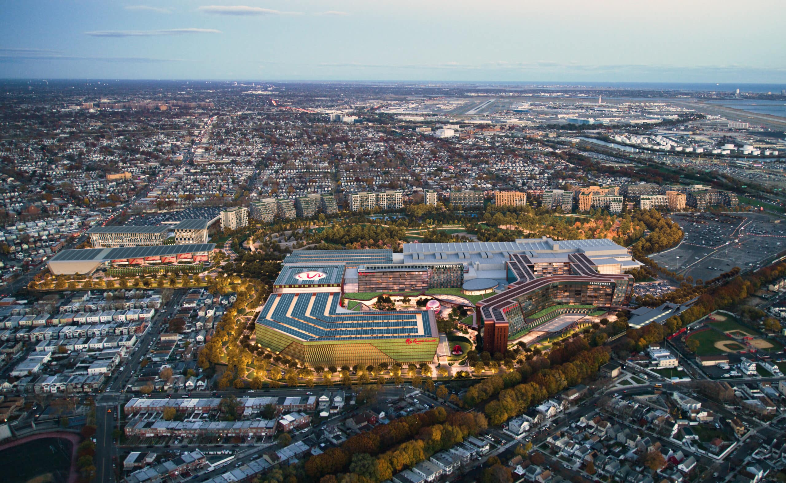 Aerial view of a large urban area with residential and industrial buildings, roads, and a sports stadium or complex in the center.