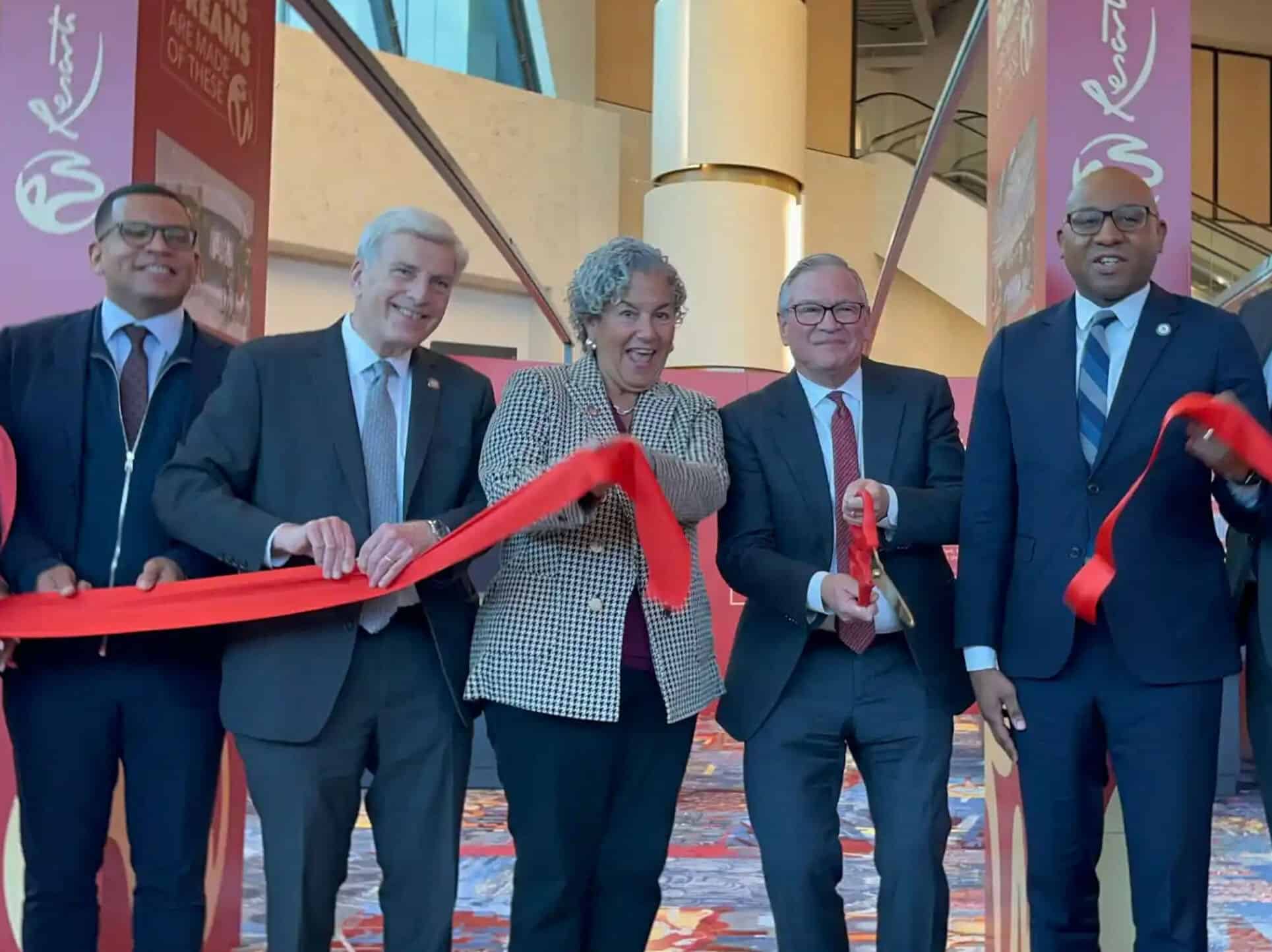 Five people in business attire cutting a red ribbon at the grand opening of Innovation Campus.