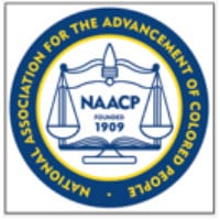 Blue circular emblem with "NAACP" text and balancing scales logo representing the National Association for the Advancement of Colored People.