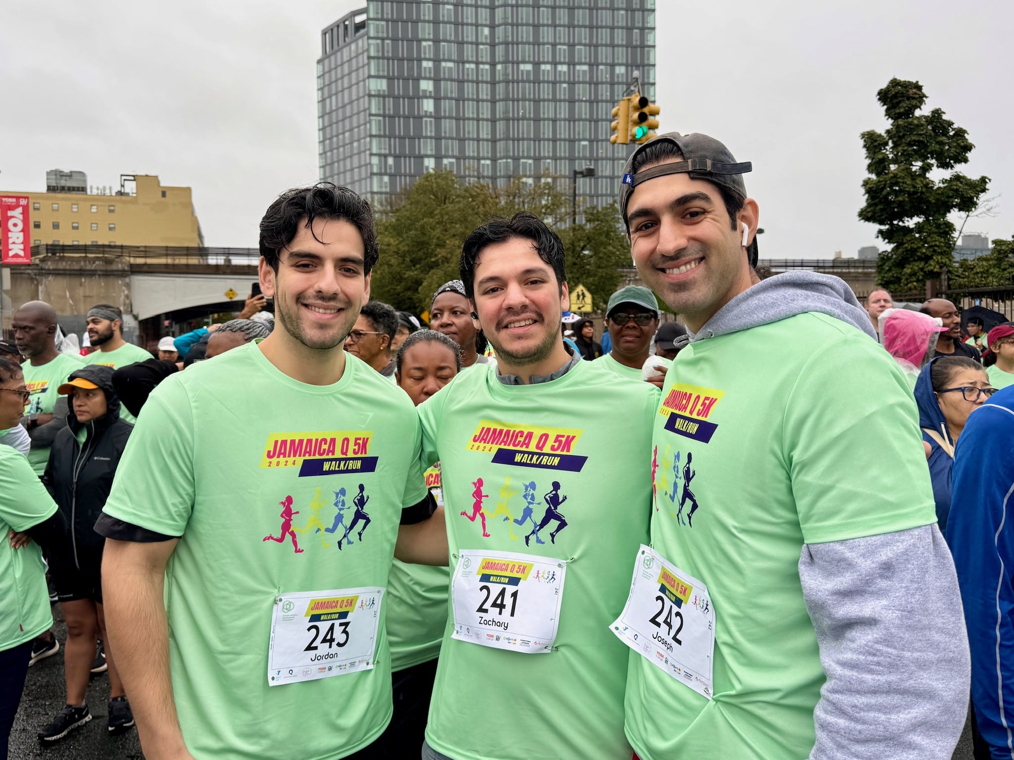 Three smiling men wearing green Jamaica 0.5K race t-shirts and race bibs